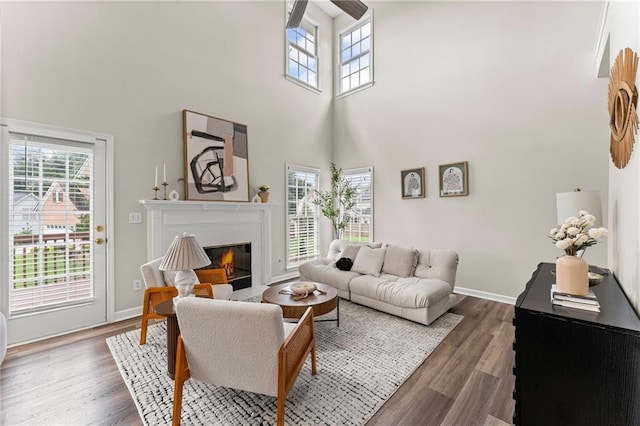 479 Rising Sun Path, Lawrenceville, GA 30043 - living room featuring a towering ceiling, healthy amount of natural light, a fireplace with flush hearth, and dark wood-style flooring