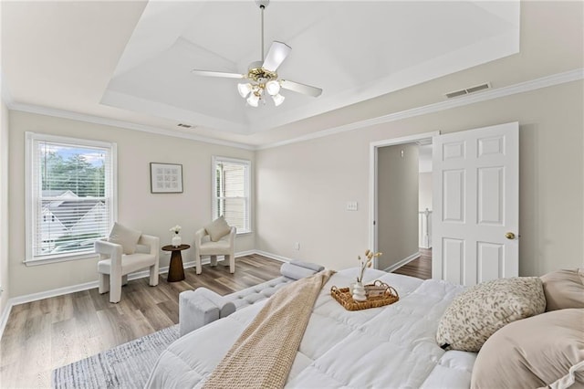 479 Rising Sun Path, Lawrenceville, GA 30043 - bedroom featuring a raised ceiling, multiple windows, wood finished floors, a ceiling fan, and crown molding
