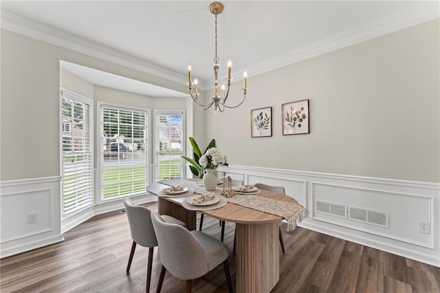 479 Rising Sun Path, Lawrenceville, GA 30043 - dining room featuring a chandelier, crown molding, wainscoting, dark wood-type flooring, and a decorative wall