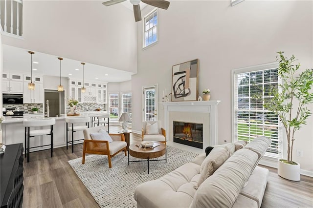 479 Rising Sun Path, Lawrenceville, GA 30043 - living room featuring a high ceiling, ceiling fan, a glass covered fireplace, and dark wood-style floors
