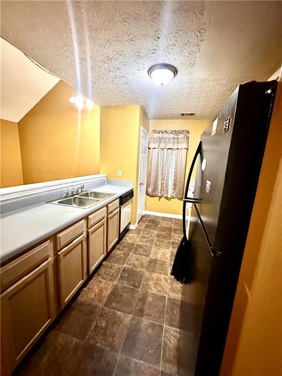 3793 Mays Ct SW, Atlanta, GA 30331 - kitchen with freestanding refrigerator, a sink, light countertops, white dishwasher, and baseboards