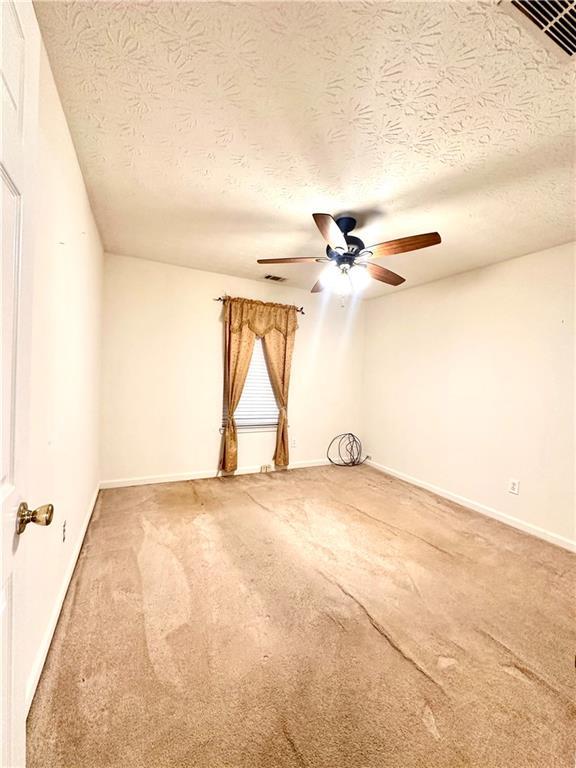 3793 Mays Ct SW, Atlanta, GA 30331 - carpeted empty room with a ceiling fan, a textured ceiling, and baseboards
