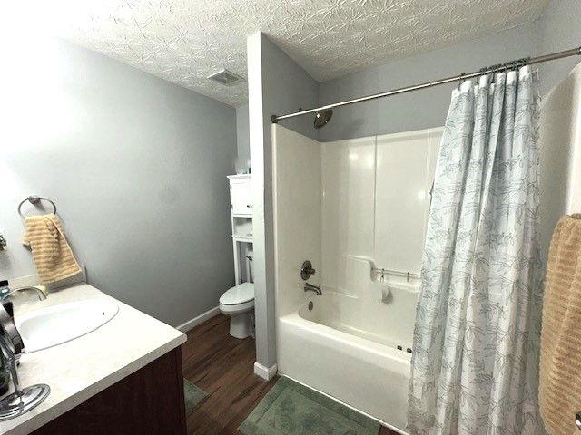 532 Oakside Pl, Acworth, GA 30102 - bathroom featuring wood finished floors, shower / bath combo with shower curtain, toilet, vanity, and baseboards