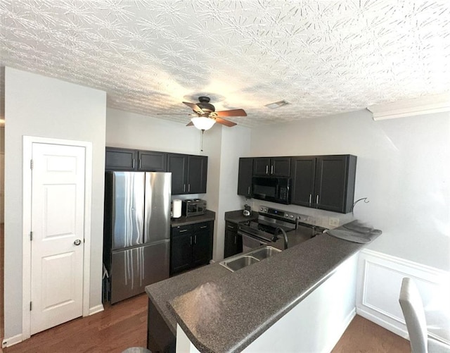 532 Oakside Pl, Acworth, GA 30102 - kitchen featuring stainless steel appliances, ceiling fan, a peninsula, dark countertops, and a sink