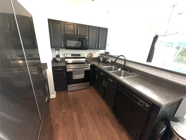 532 Oakside Pl, Acworth, GA 30102 - kitchen featuring black appliances, a sink, dark countertops, dark wood-style flooring, and a peninsula