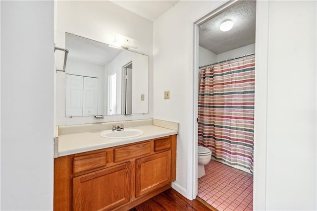 full bath featuring toilet, a textured ceiling, a shower with shower curtain, and vanity