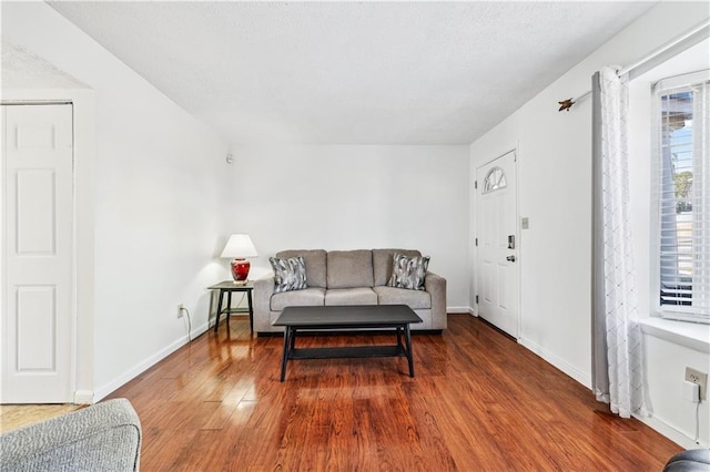 living area featuring baseboards and wood finished floors