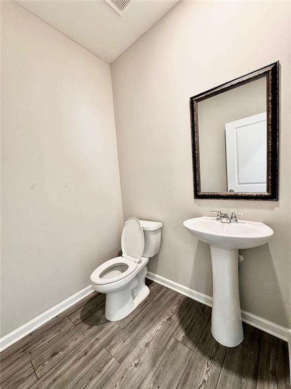 bathroom with toilet and hardwood / wood-style floors