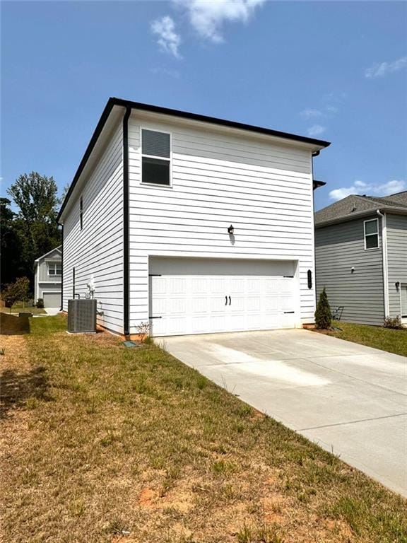 view of home's exterior featuring cooling unit, a lawn, and a garage