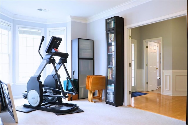 workout room with hardwood / wood-style flooring and ornamental molding