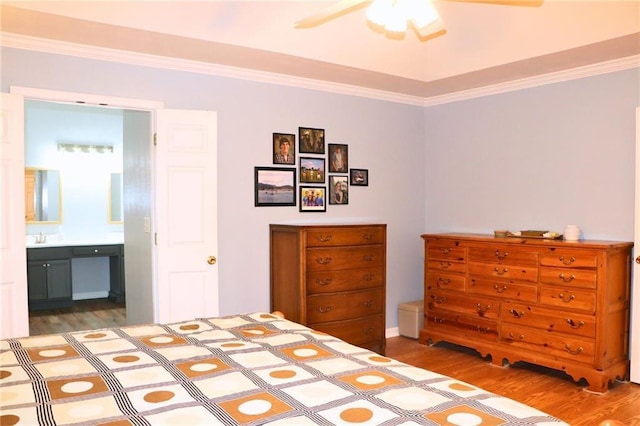 bedroom featuring crown molding, wood-type flooring, ensuite bathroom, and sink