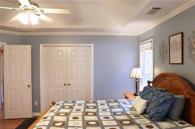 bedroom featuring crown molding, ceiling fan, wood-type flooring, and a closet