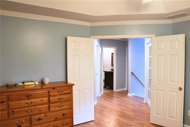 bedroom with ornamental molding and light wood-type flooring