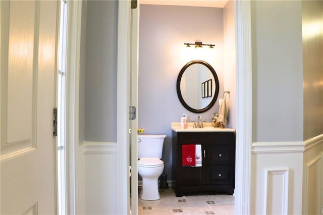 bathroom featuring vanity, tile patterned floors, and toilet