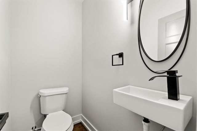 bathroom with hardwood / wood-style floors, toilet, and sink