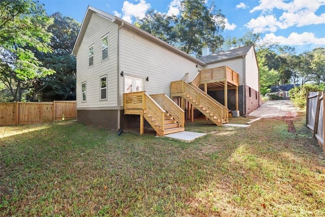 rear view of property featuring a wooden deck, a yard, and french doors