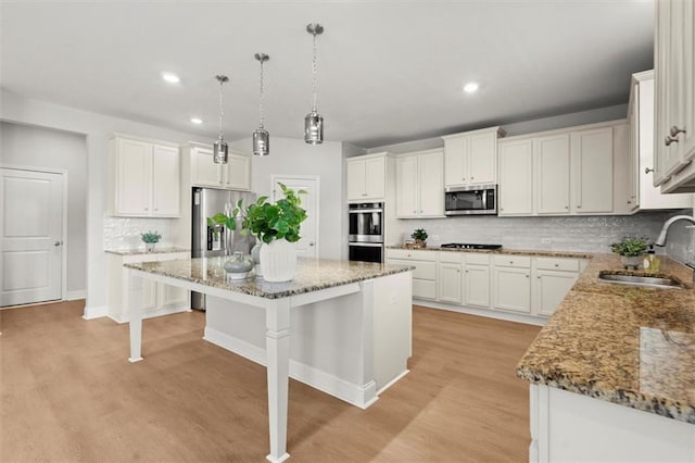 7410 Ansley View Ln, Cumming, GA 30028 - kitchen featuring appliances with stainless steel finishes, light wood-type flooring, recessed lighting, a kitchen island, and a kitchen bar