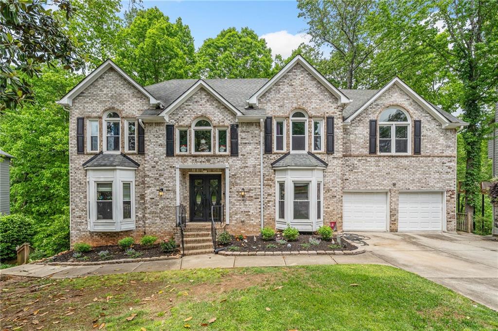 4365 Dover Crossing Dr, Marietta, GA 30066 - view of front of house with an attached garage, a front yard, driveway, and brick siding