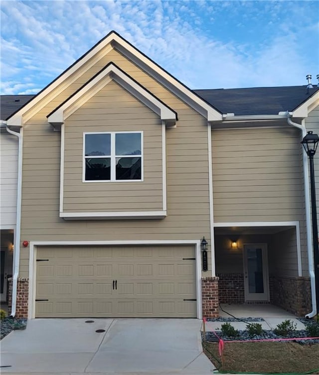 view of front of property with brick siding, driveway, and an attached garage