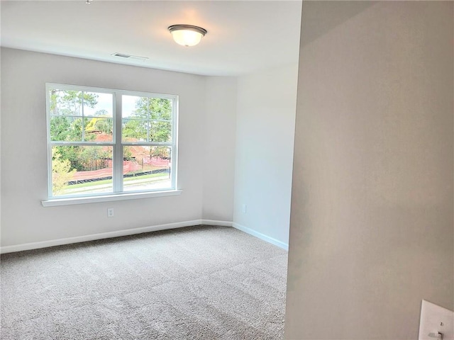 carpeted spare room featuring visible vents and baseboards