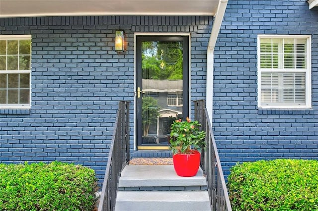 view of exterior entry featuring brick siding