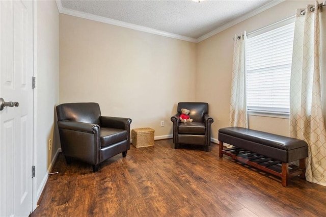 sitting room with wood finished floors, crown molding, a textured ceiling, and baseboards