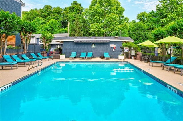 community pool featuring fence and a patio area
