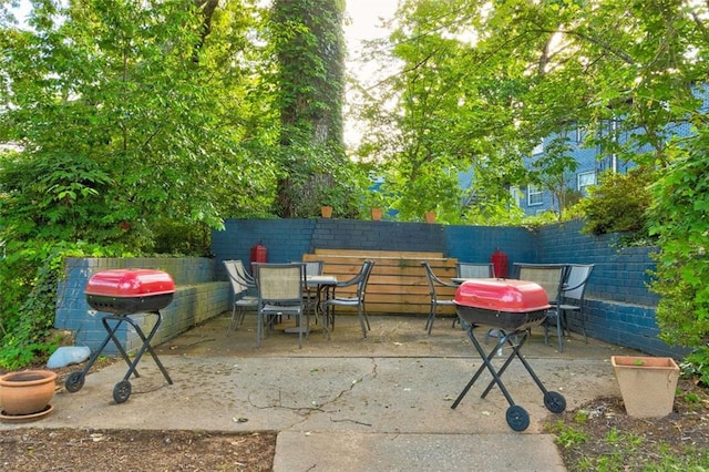 view of patio featuring outdoor dining space, a fenced backyard, and grilling area