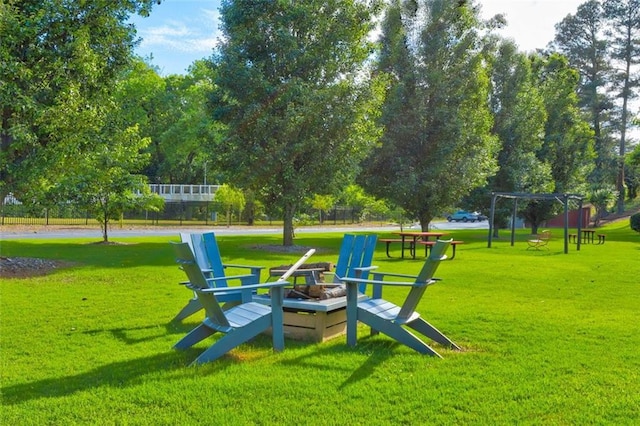 view of home's community featuring a lawn and a fire pit