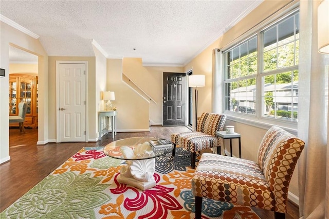 sitting room with crown molding, wood finished floors, a textured ceiling, and baseboards