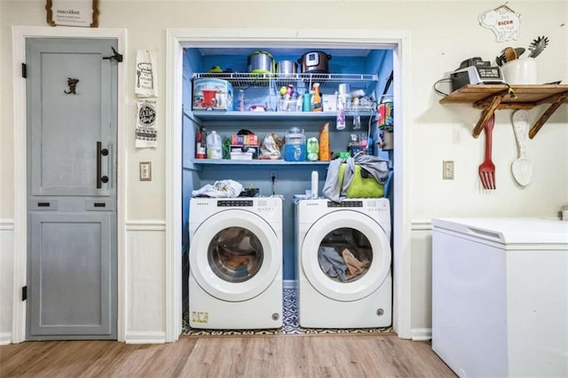 washroom with washer and clothes dryer and light wood-type flooring