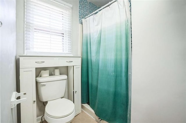 bathroom featuring a shower with curtain and toilet