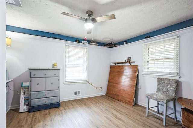 sitting room with ceiling fan, a textured ceiling, and light hardwood / wood-style flooring