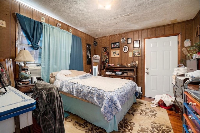 bedroom featuring a textured ceiling and wood walls