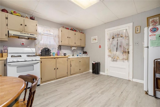 kitchen featuring sink, tasteful backsplash, cream cabinets, white appliances, and light wood-type flooring