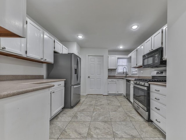 kitchen featuring stainless steel appliances, white cabinetry, and sink