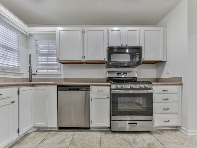 kitchen with stainless steel appliances, white cabinets, and light tile patterned flooring