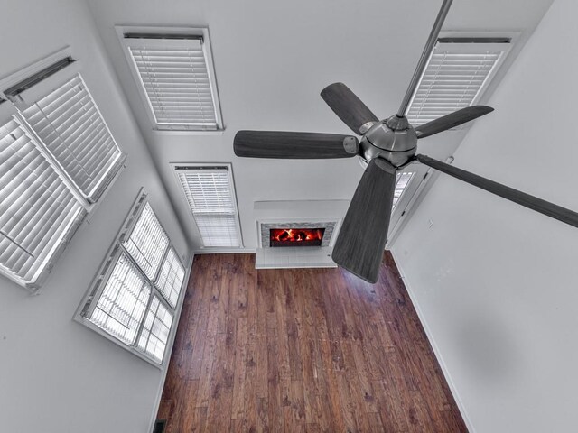 unfurnished living room with dark wood-type flooring and ceiling fan