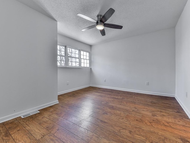 unfurnished room with dark hardwood / wood-style floors, a textured ceiling, and ceiling fan