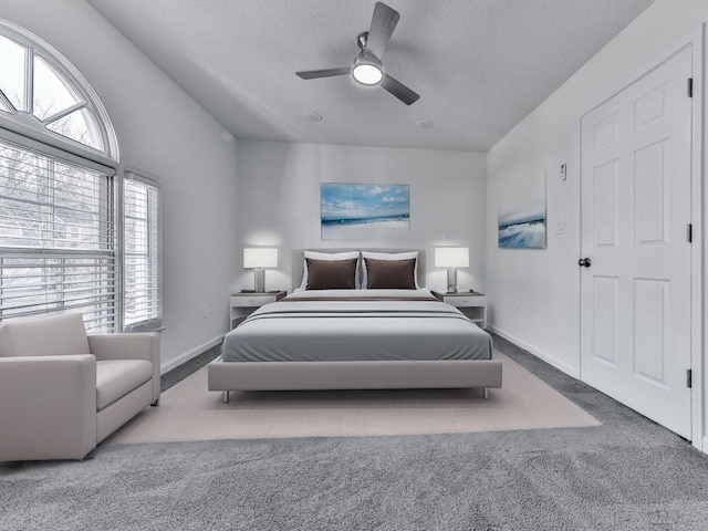 carpeted bedroom featuring ceiling fan and a textured ceiling