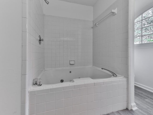 bathroom featuring tiled shower / bath combo and wood-type flooring