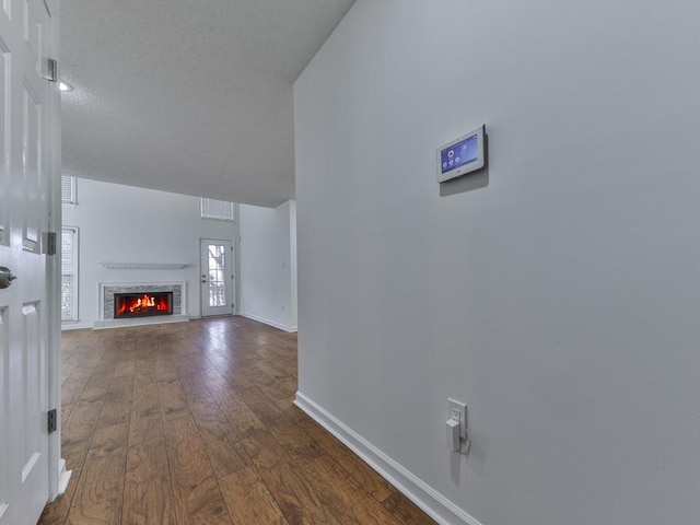 unfurnished living room with a high end fireplace and dark hardwood / wood-style floors