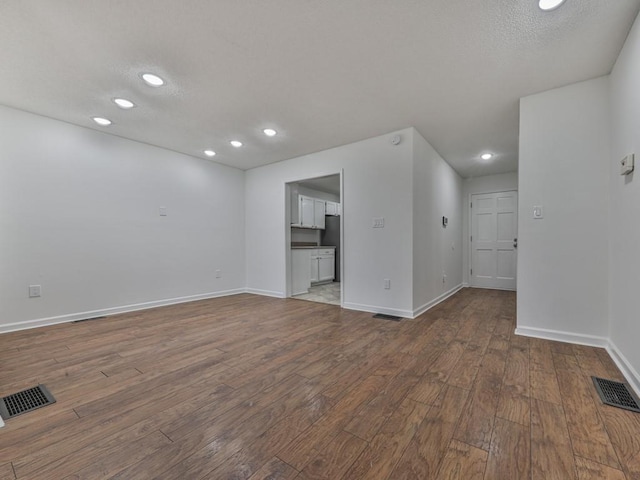 unfurnished room featuring hardwood / wood-style floors and a textured ceiling