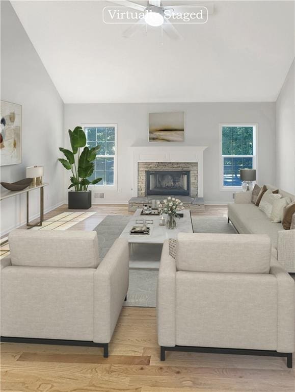 living room with a healthy amount of sunlight, ceiling fan, light hardwood / wood-style flooring, and a fireplace