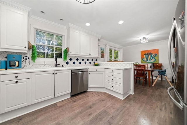 5552 Knox Pl, Peachtree Corners, GA 30092 - kitchen featuring stainless steel appliances, a sink, a peninsula, crown molding, and light countertops