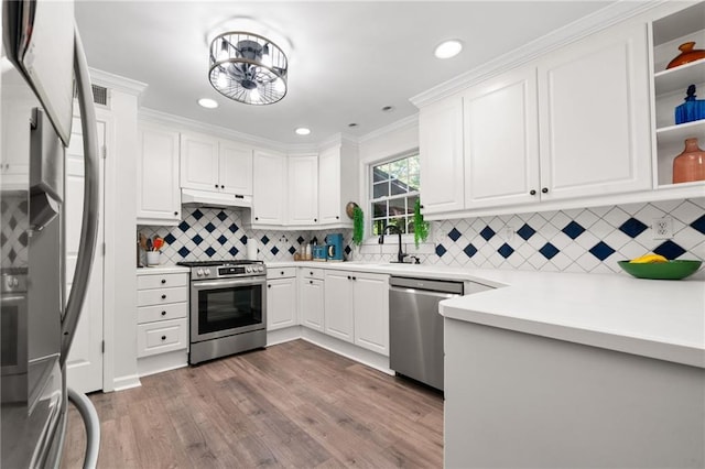 5552 Knox Pl, Peachtree Corners, GA 30092 - kitchen with stainless steel appliances, white cabinetry, wood finished floors, ornamental molding, and recessed lighting