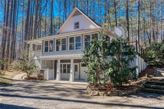 view of front of property with a chimney and a sunroom