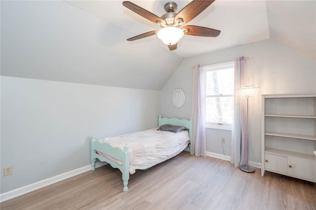 bedroom featuring lofted ceiling, wood finished floors, and baseboards