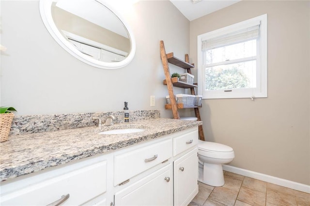 bathroom with toilet, baseboards, and vanity