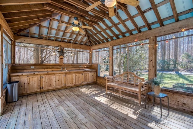 unfurnished sunroom with ceiling fan, vaulted ceiling, and a sink